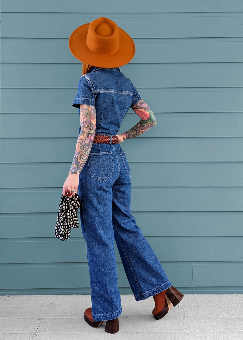 Rolla's Jeans retro 70s inspired blue denim jumpsuit featuring a collared neckline, button front, patch sailor pockets at front, and a wide sailor leg with a cropped ankle length.