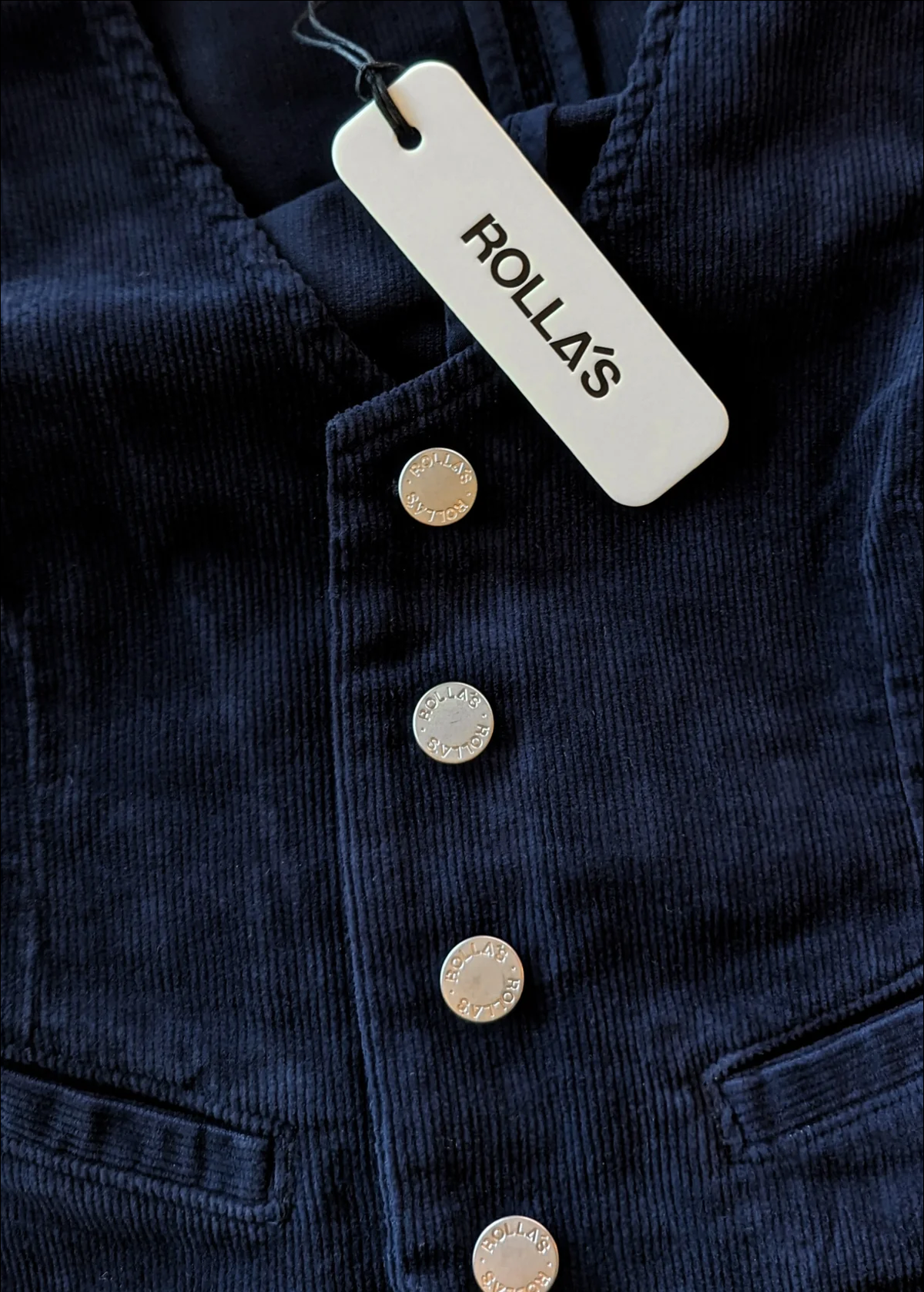 Rolla's Jeans Navy Corduroy Dallas Vest: 70s inspired vest with a v-neckline, button front, slit pockets, and adjustable buckle at back. 