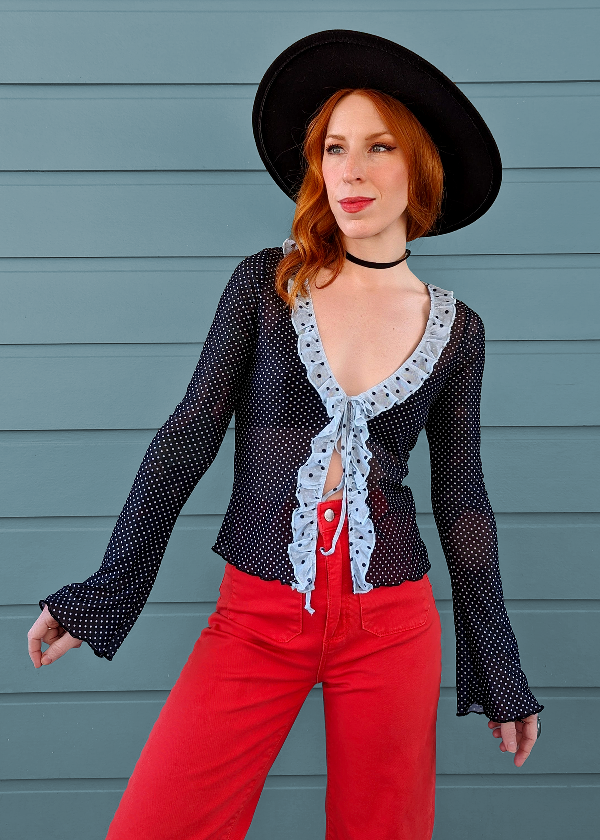 Motel Rocks slinky black and sky blue mesh cardigan top with long fluted bell sleeves and tie front closure. Polka dot design with ruffled neckline. 