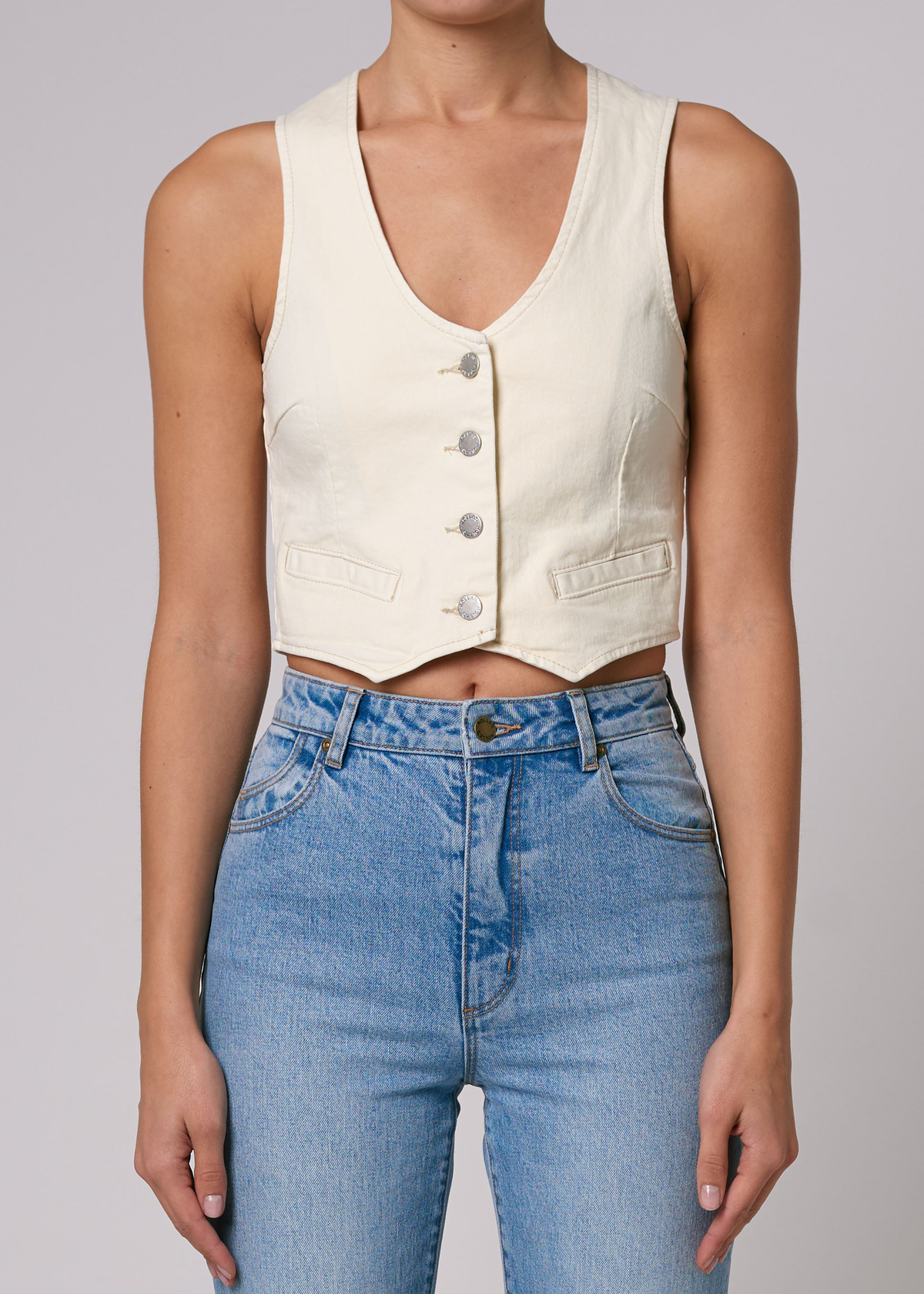 70s 80s inspired Rolla's Jeans Denim Dallas Vest in Buttercream Ivory. V-neckline, button front, and adjustable buckle at back.