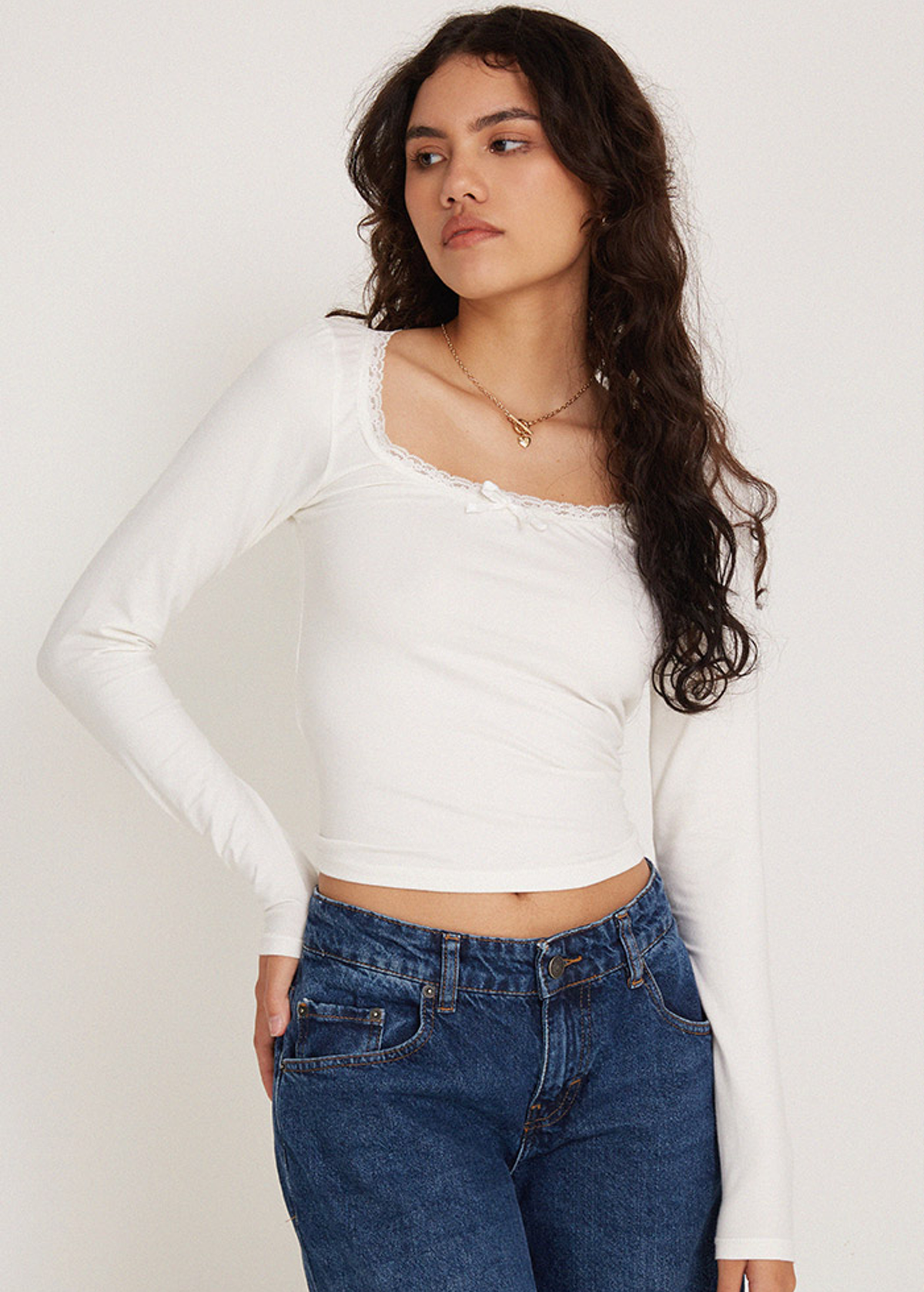 90s inspired white stretch cotton long sleeve tee with scoop neckline and lace and bow trim at neckline. by Motel Rocks