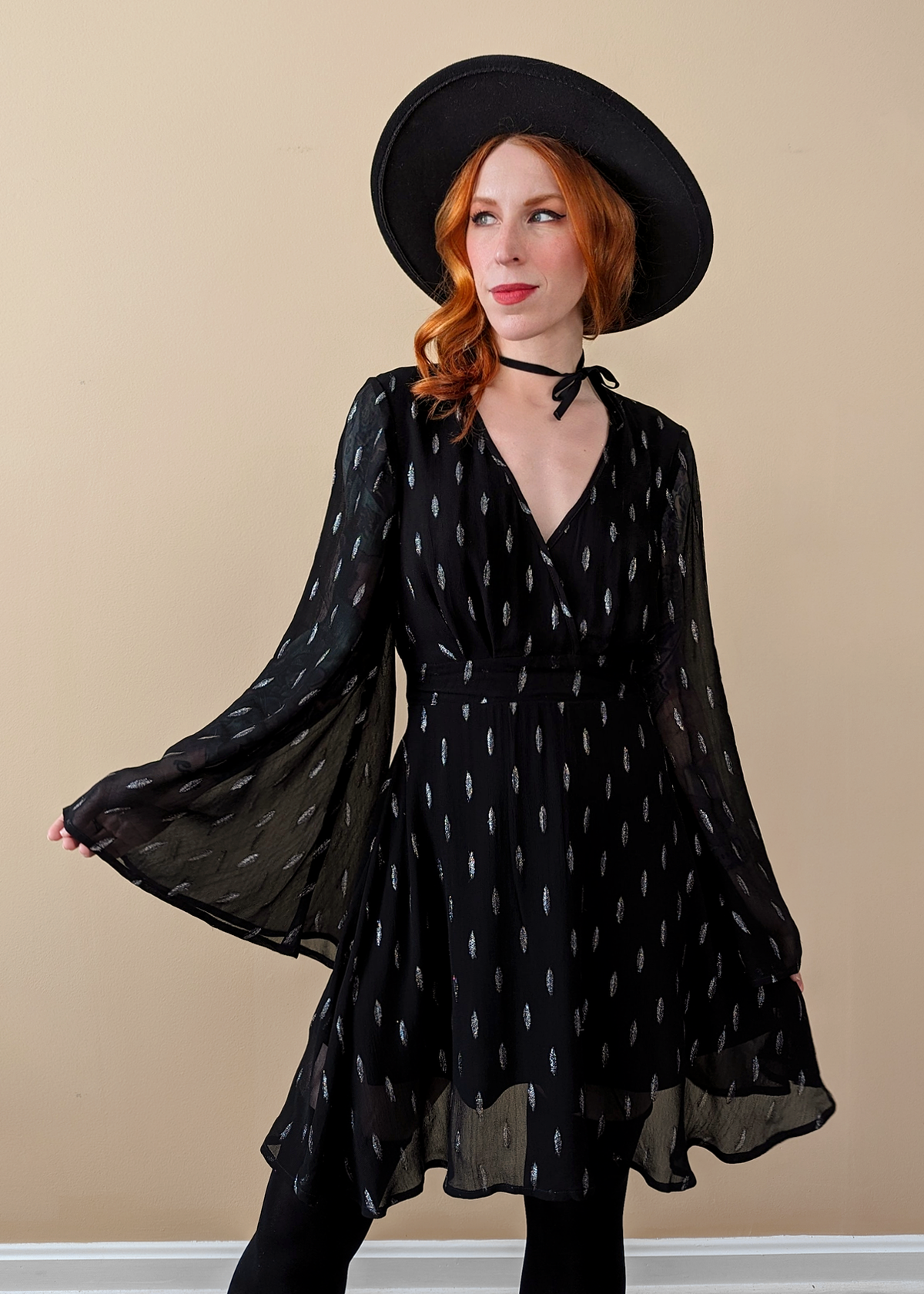 Stevie Nicks vibes. Witchy Angel Bell Sleeve Mini dress with v-neckline, and fluttery, floaty fit. Black chiffon with silver metallic threading details.