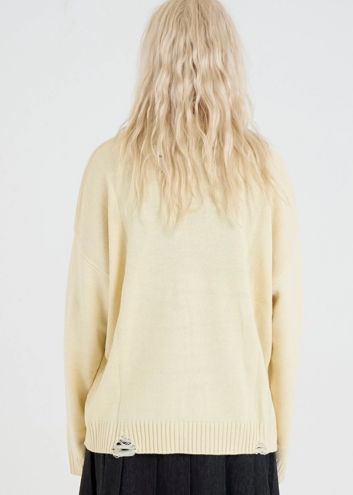 Back view of a person wearing an oversized cream sweater 