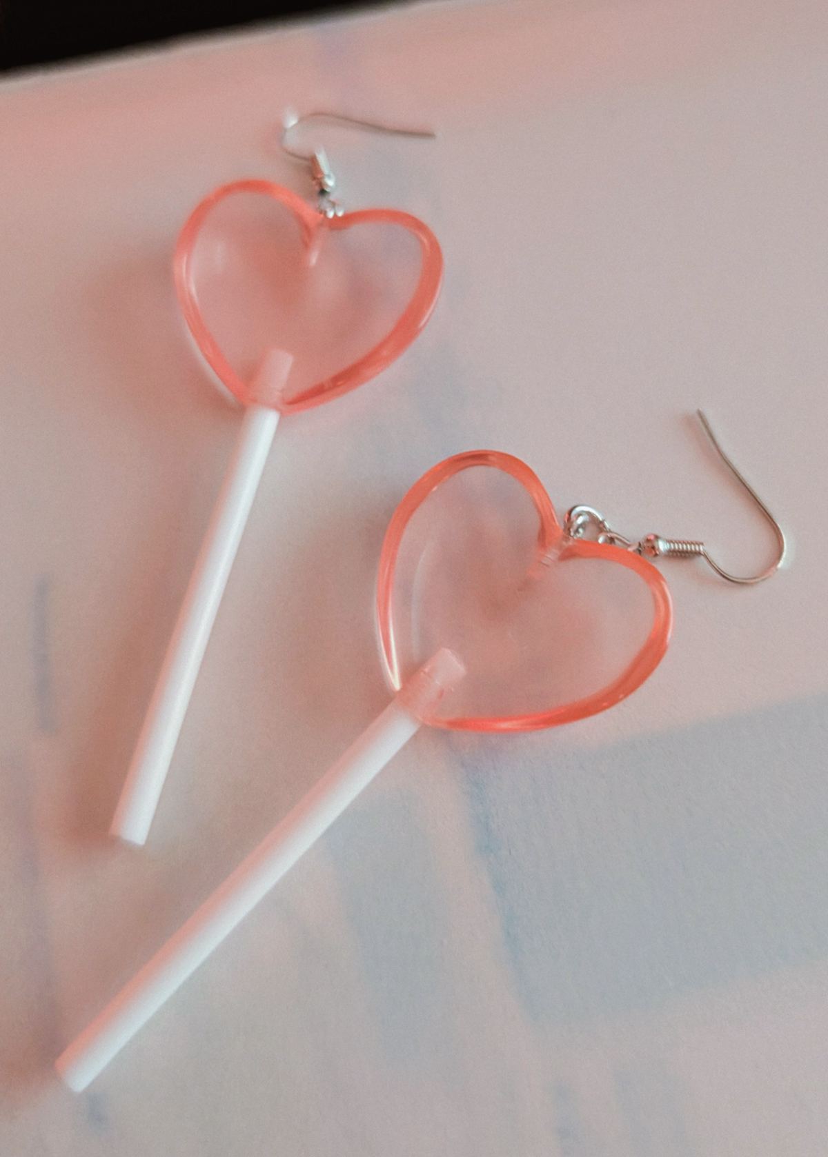 Heart-shaped lollipop earrings on a light background