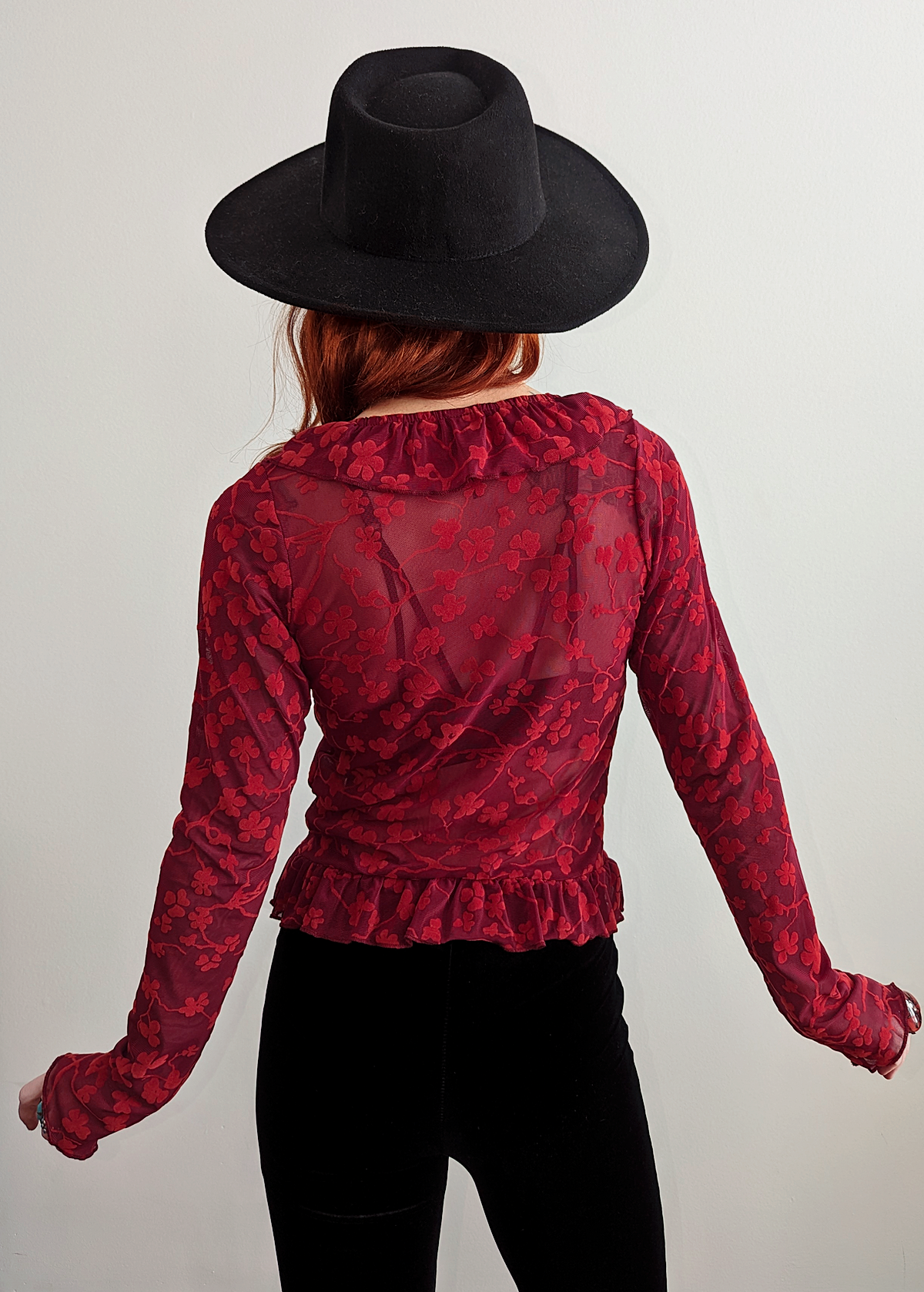 90s inspired burgundy red ruffled cardigan top made of a slinky mesh fabrication with flocked velvet floral design. Deep v-neckline, hook and eye closure at front. Long sleeves. By Motel Rocks