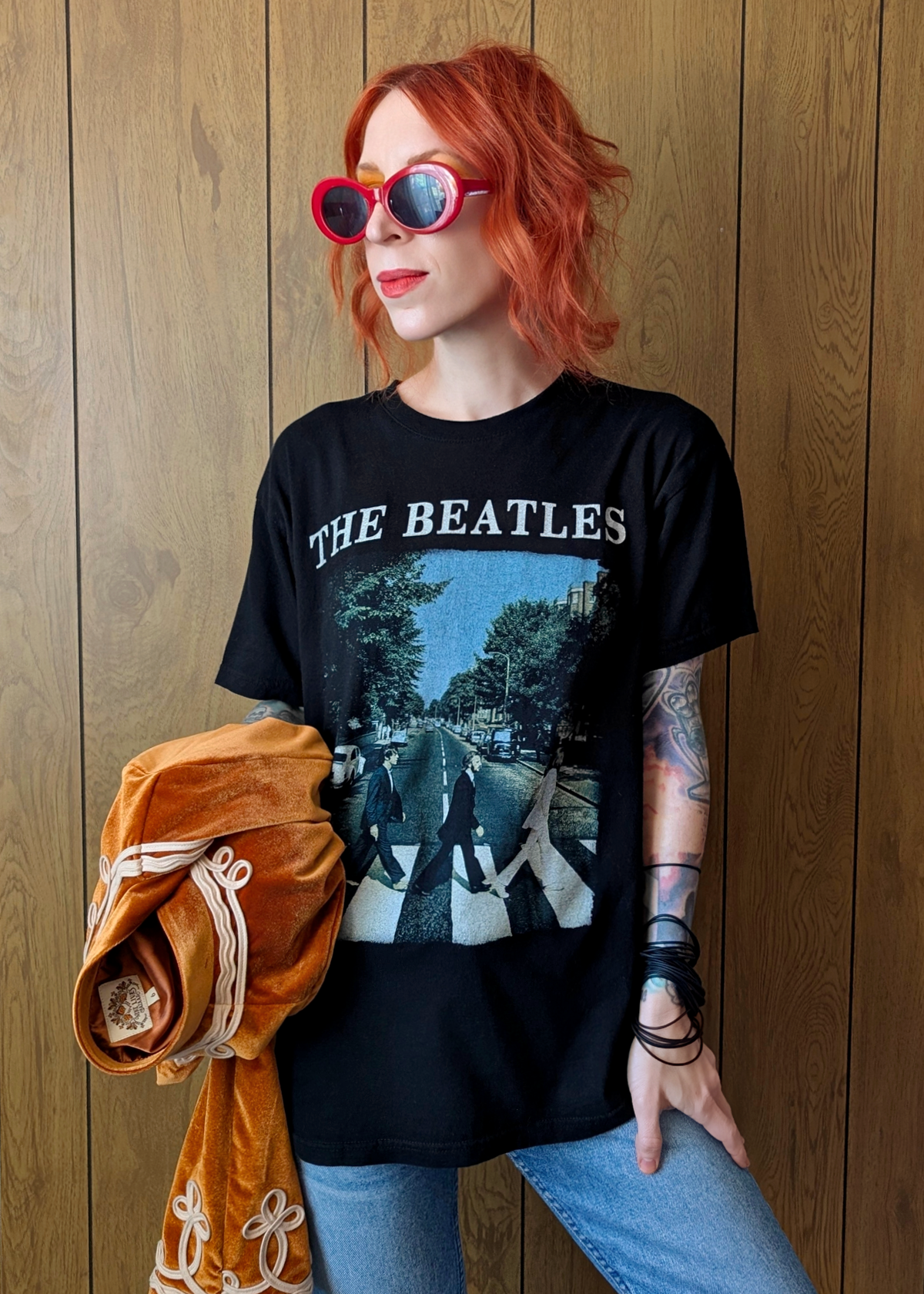 Person wearing a 'The Beatles' t-shirt with a wooden background
