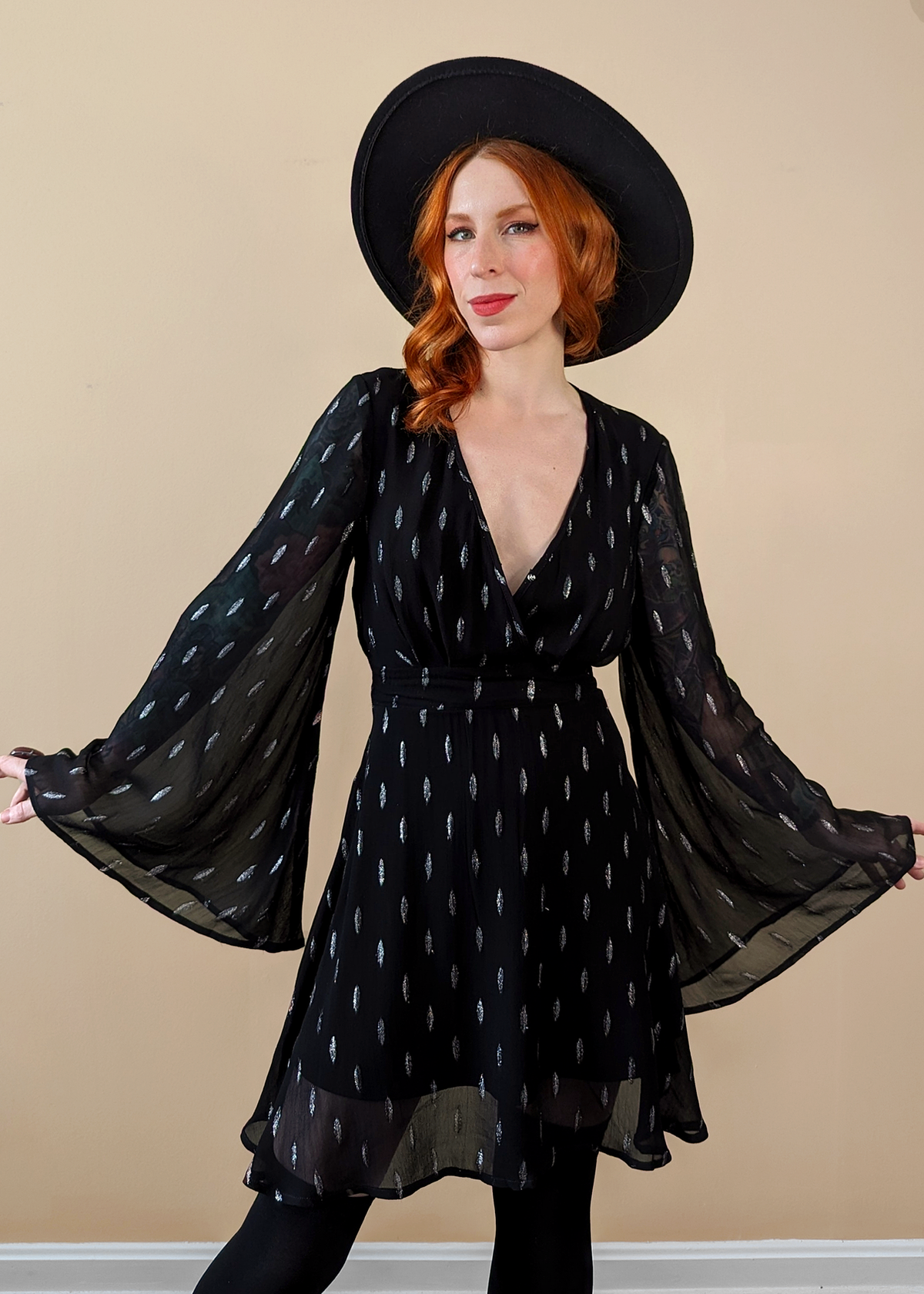 Stevie Nicks vibes. Witchy Angel Bell Sleeve Mini dress with v-neckline, and fluttery, floaty fit. Black chiffon with silver metallic threading details.