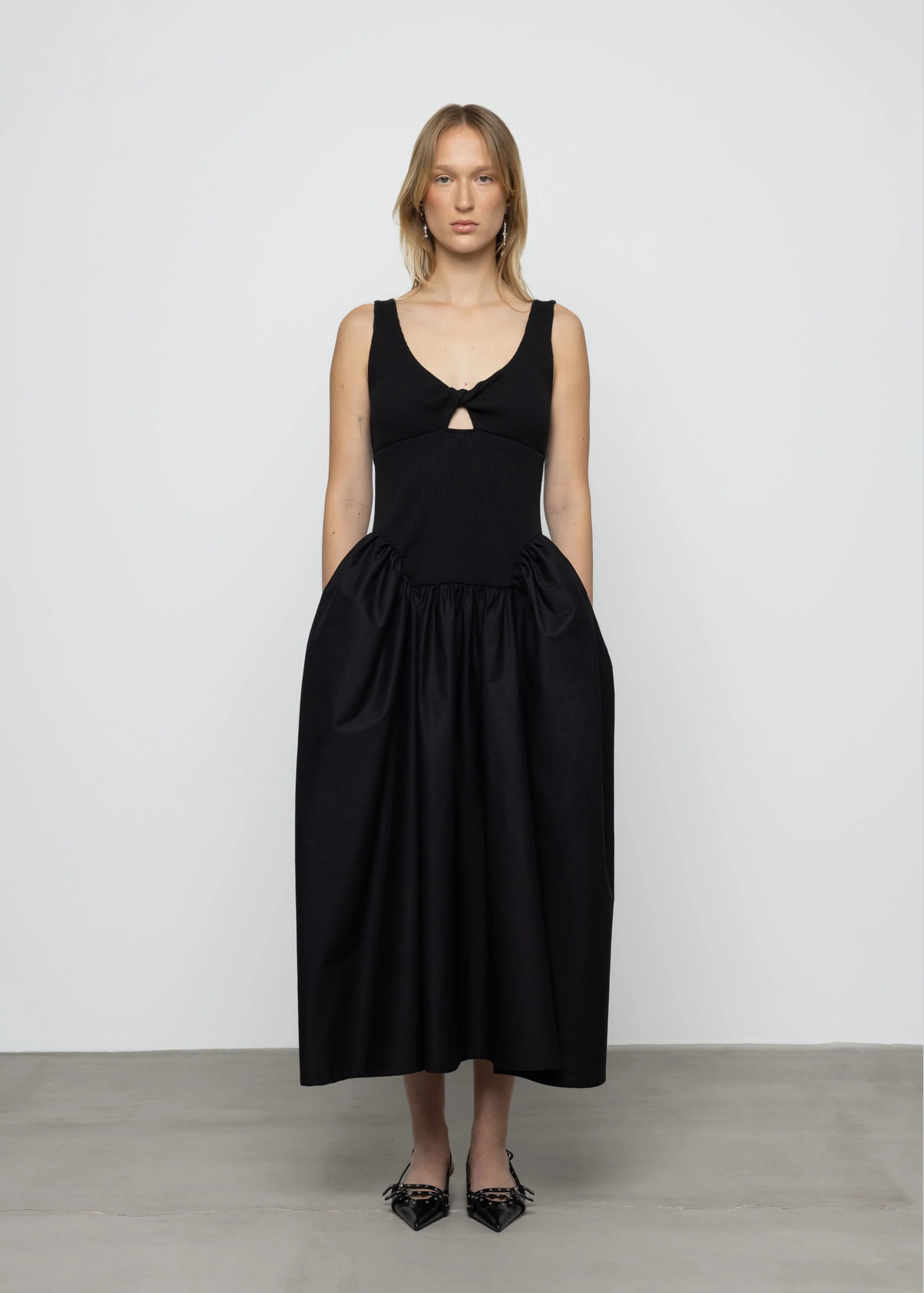 Woman wearing a black dress with cut-out details on a white background