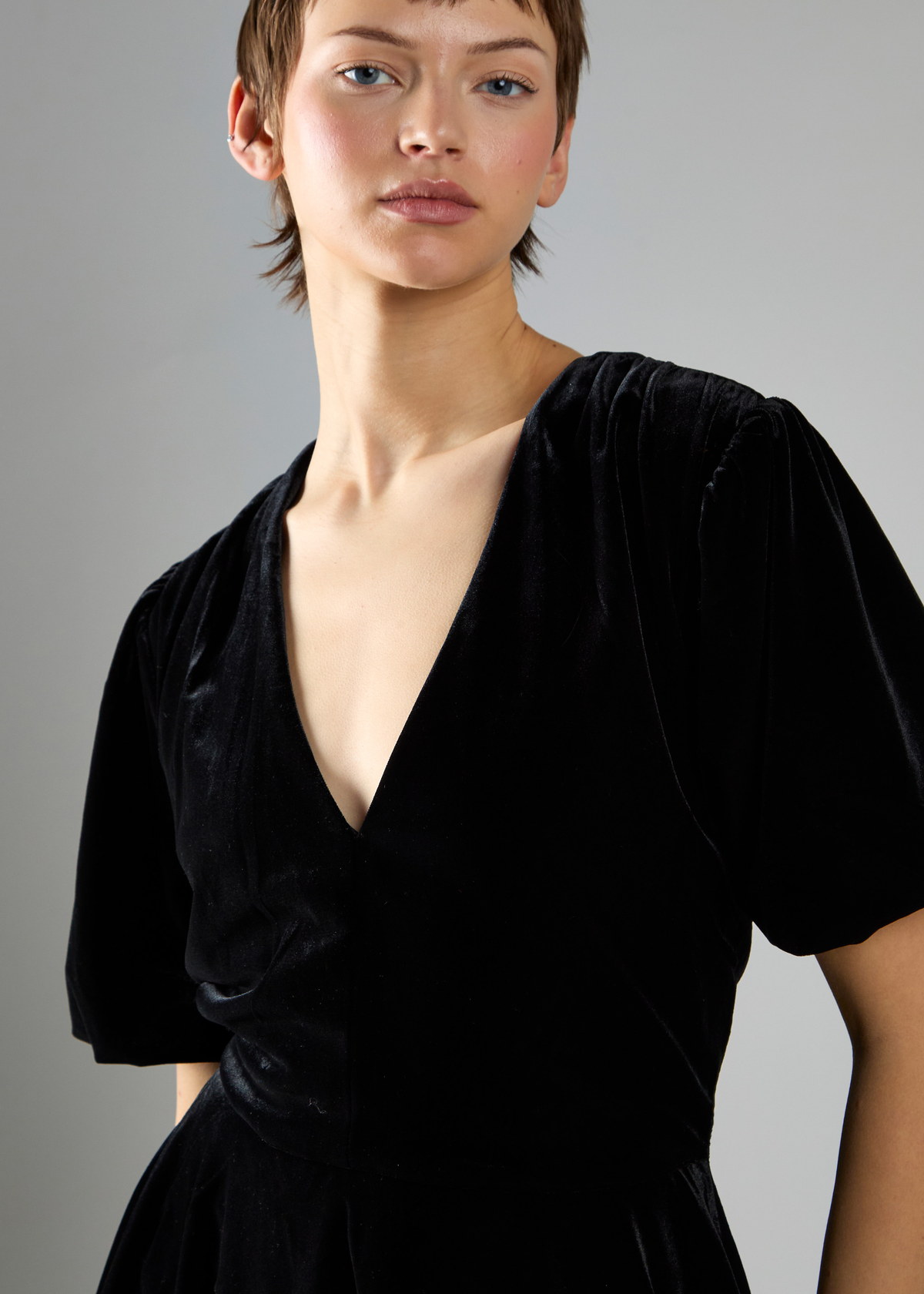 Woman wearing a black dress against a gray background