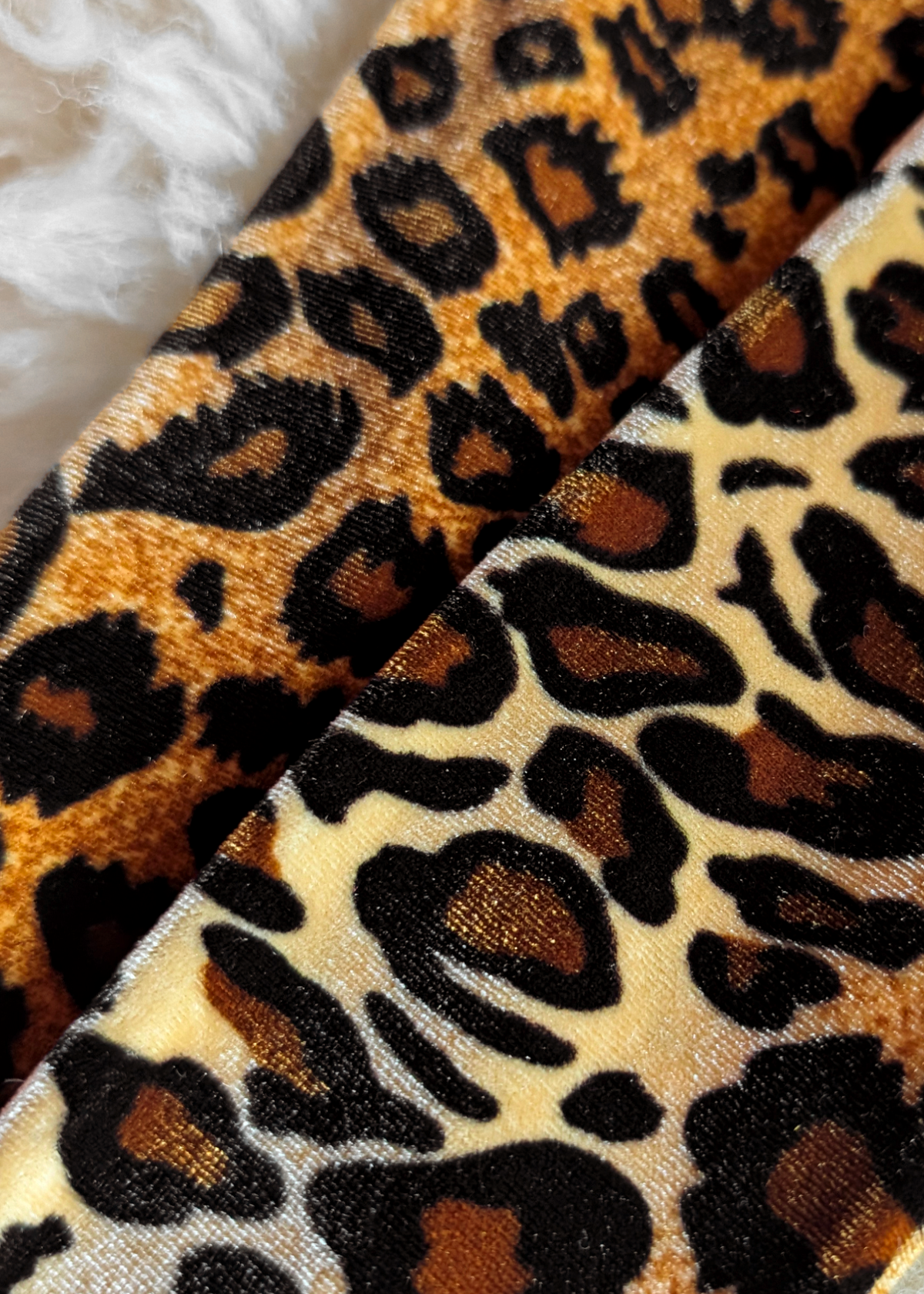 Close-up of leopard print fabric with a fluffy white background