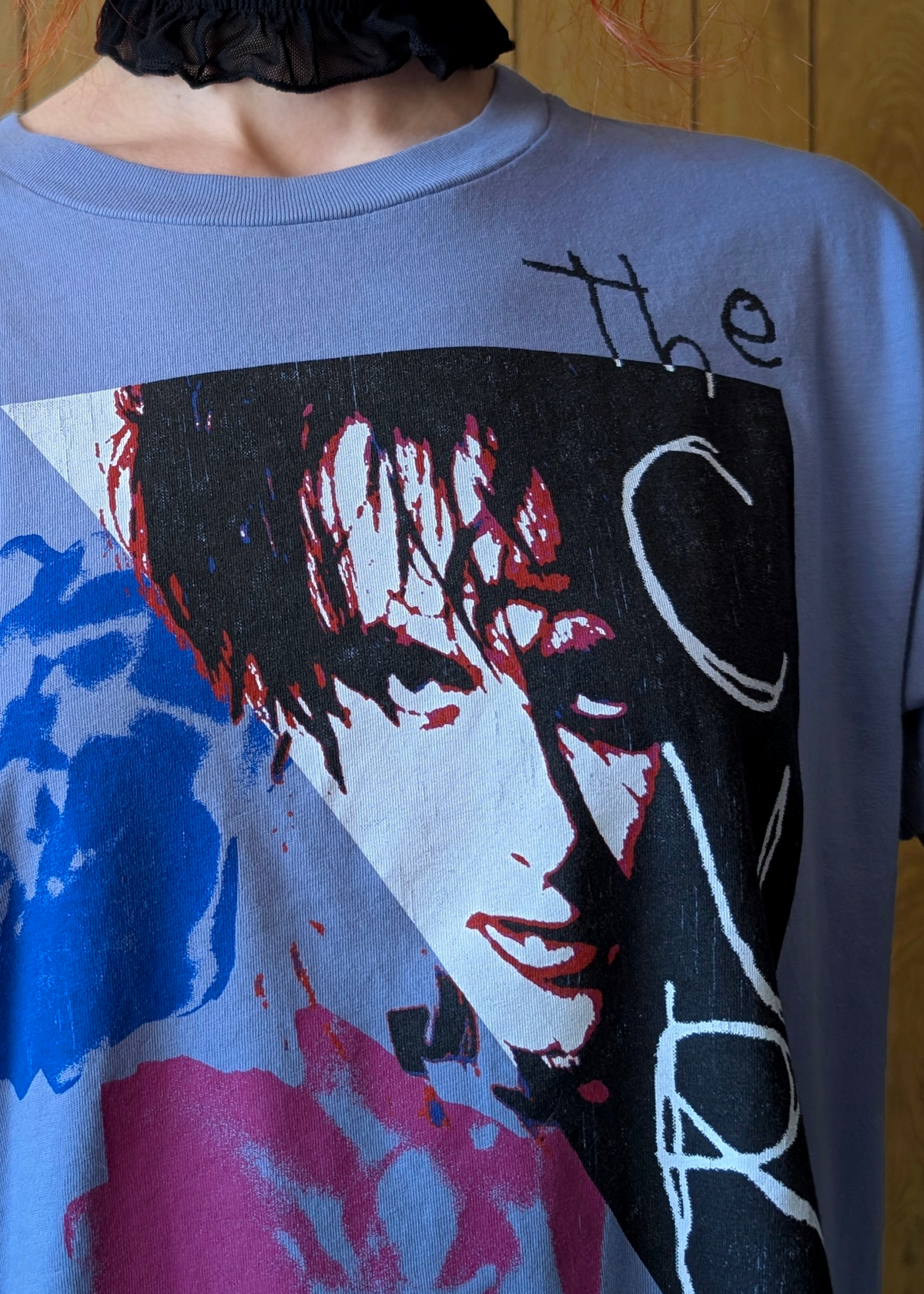 Close up detail of a Cure graphic tee with Robert Smith graphics