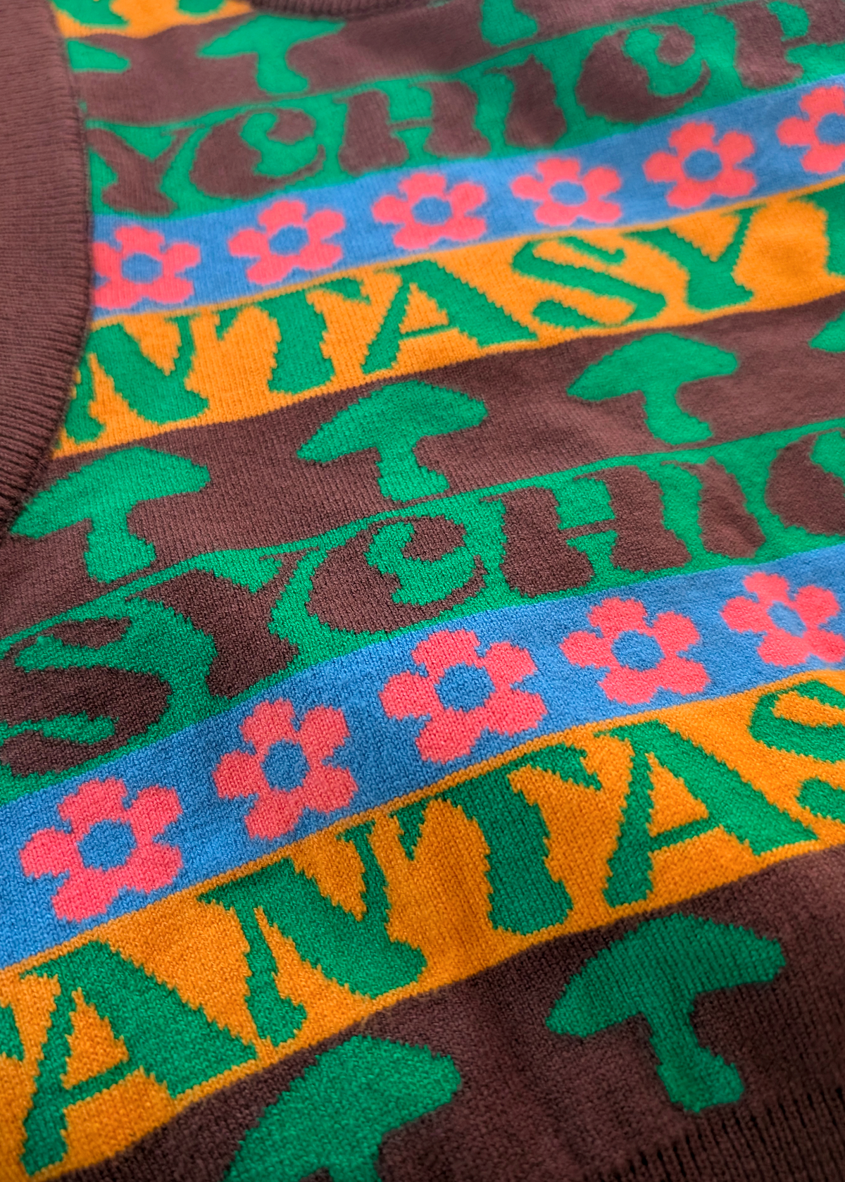 Close-up of a colorful patterned fabric with text and floral designs.