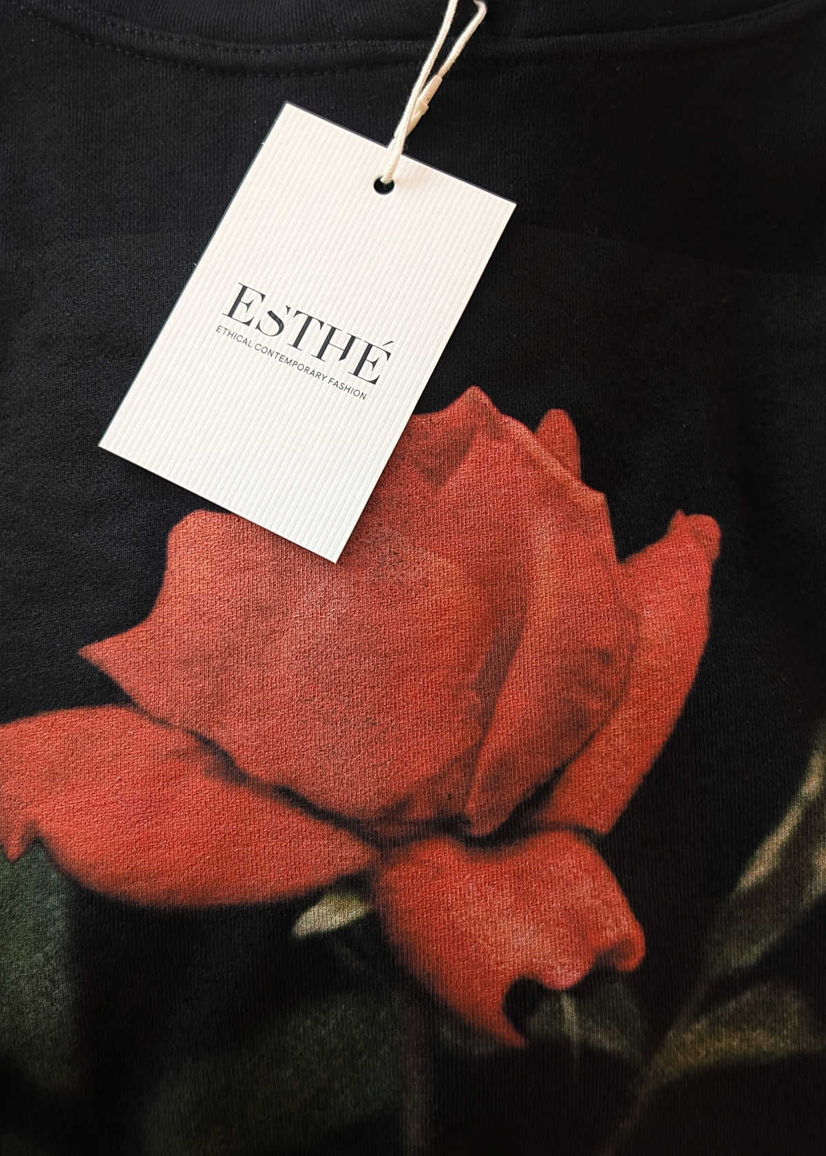 Black garment with a red floral design and 'ESTHE' tag.