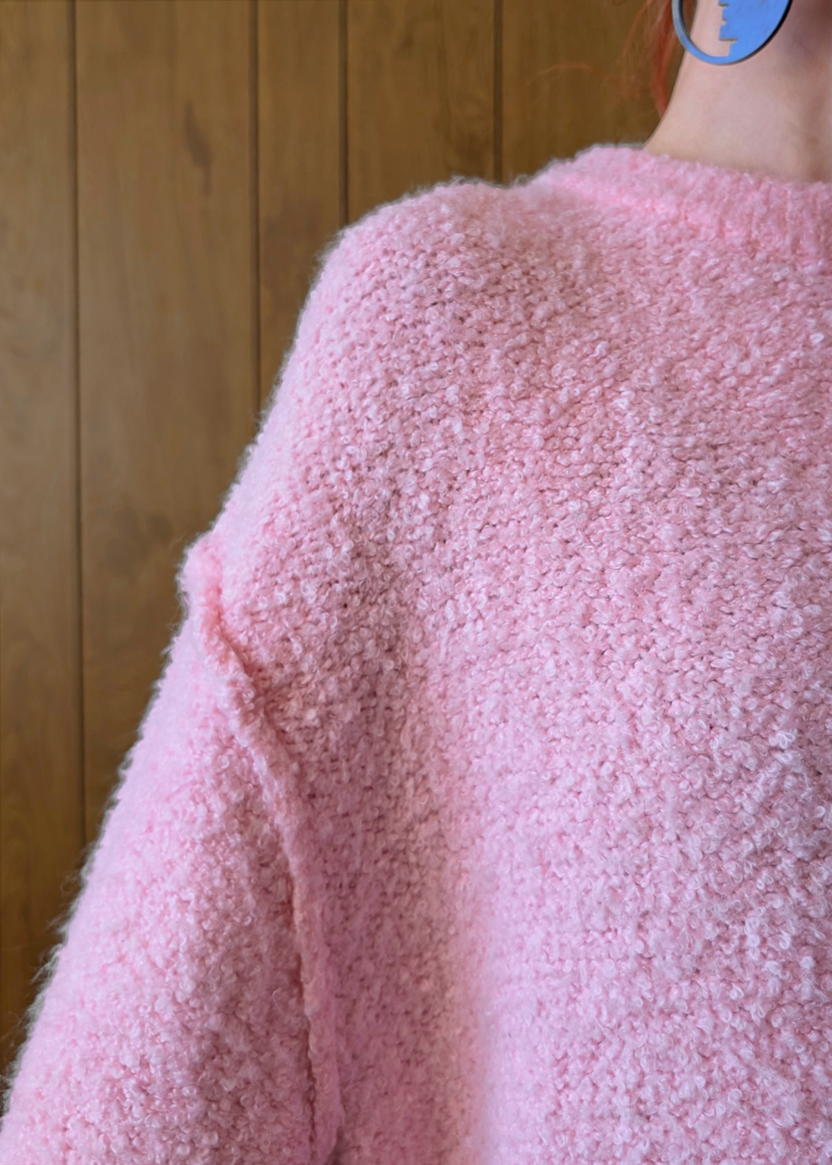 Close-up of a pink textured garment against a wooden background