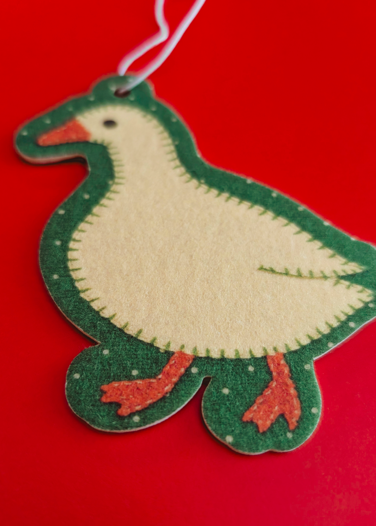 Goose shaped hanging air freshener on a red background