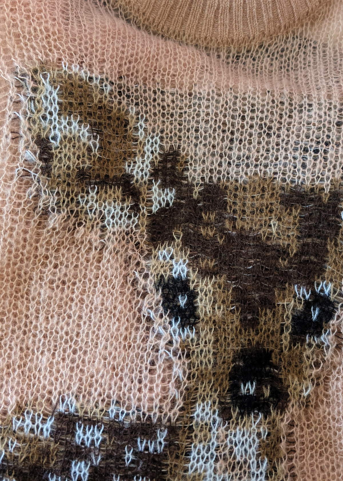 Close-up details of the deer design on the dusty pink open knit sweater