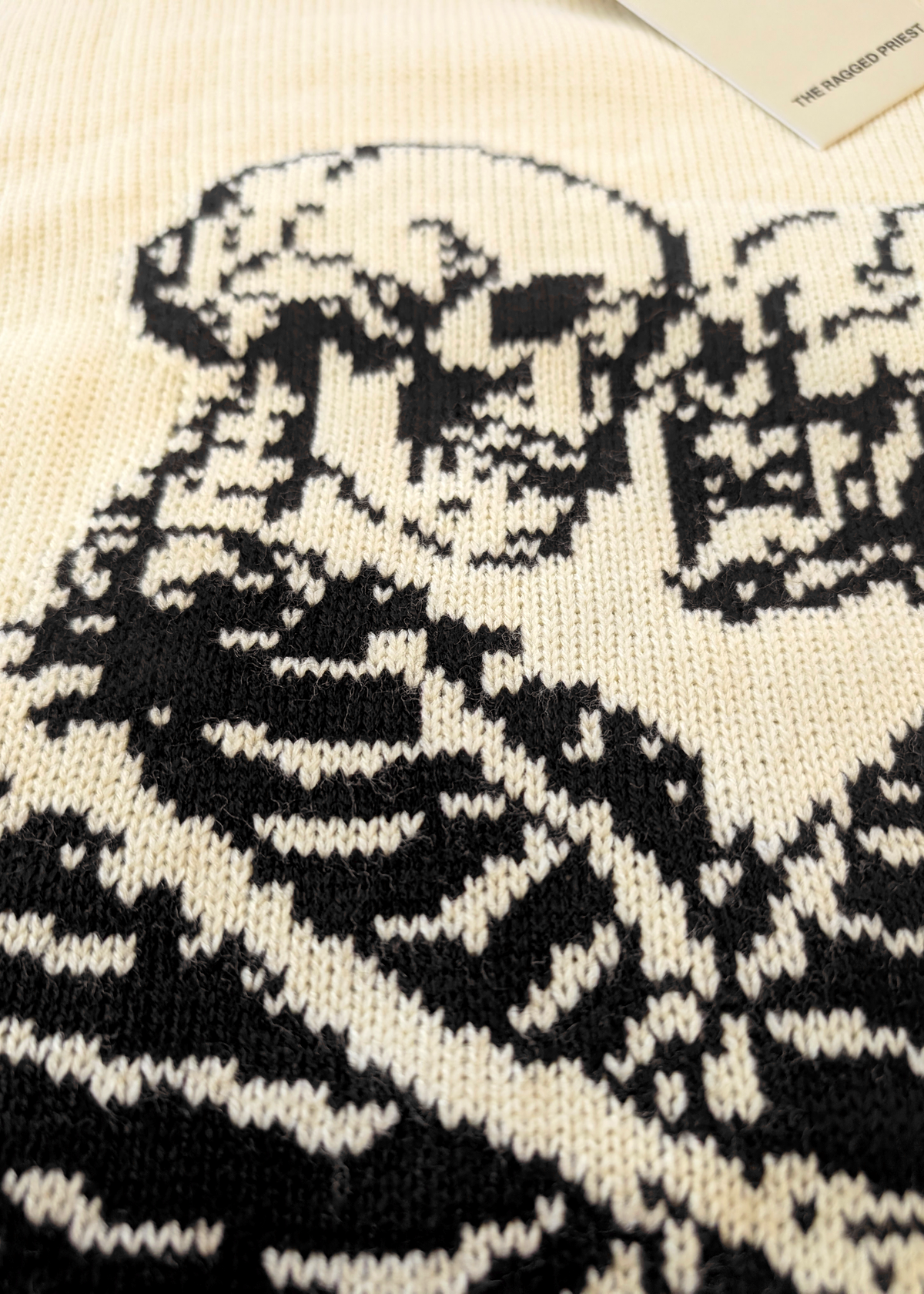 Close-up of a black skeleton design on a cream sweater