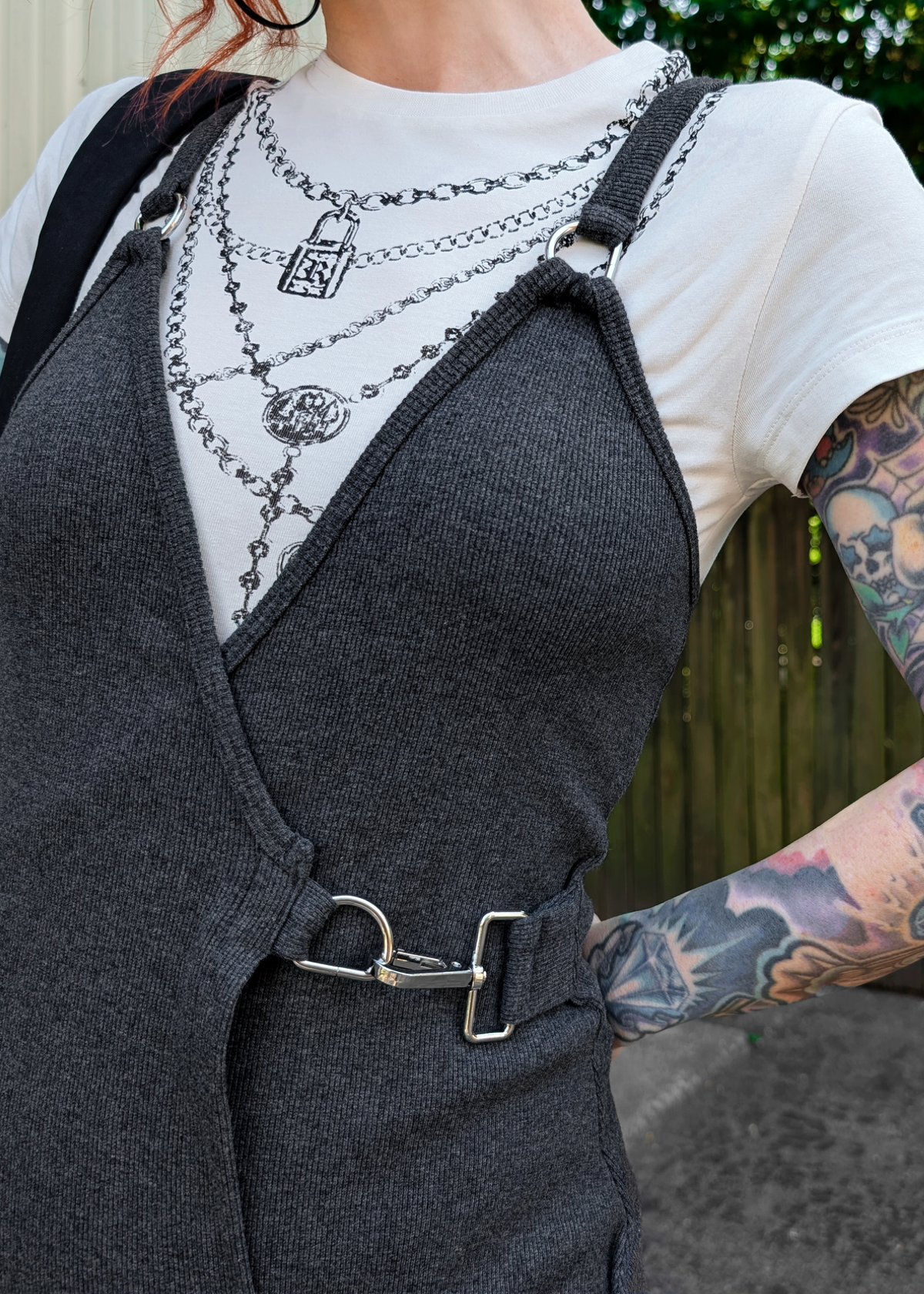 Person wearing a charcoal grey ribbed slip dress with a white shirt underneath, standing outdoors.