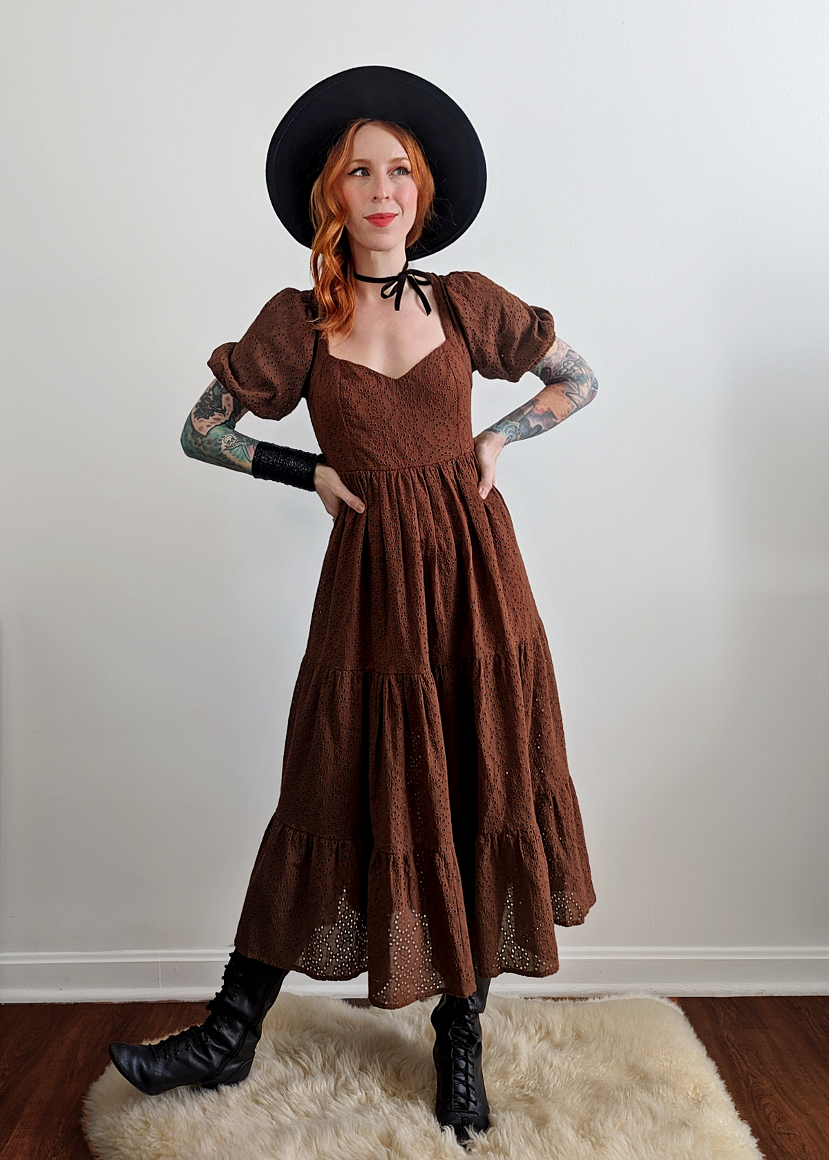 70s inspired prairie dress made of 100% eyelet cotton in a walnut brown colorway. Features puff sleeves, sweetheart neckline, smocked back with tie closure, and ruffled tiered skirt. 