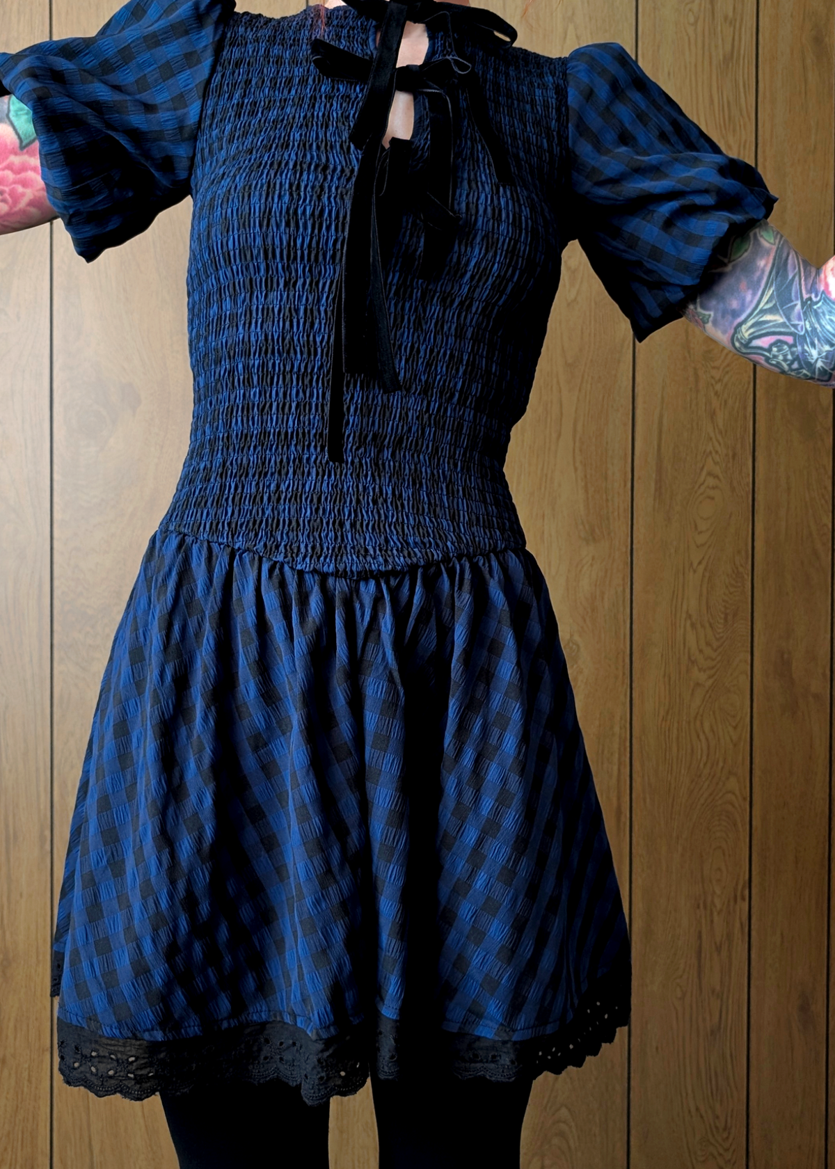 Blue and black patterned dress with puffed sleeves against a wooden background