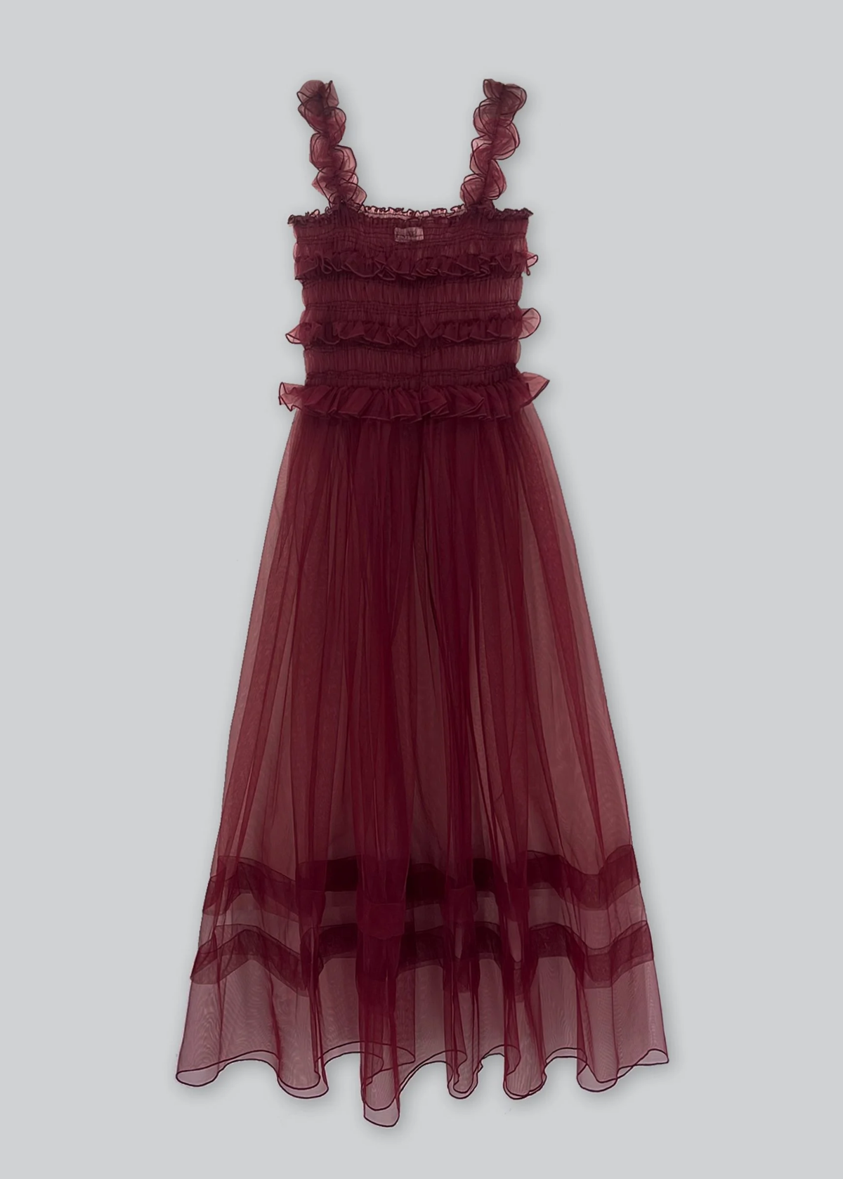 Burgundy sheer tulle dress with smocked details on a light gray background