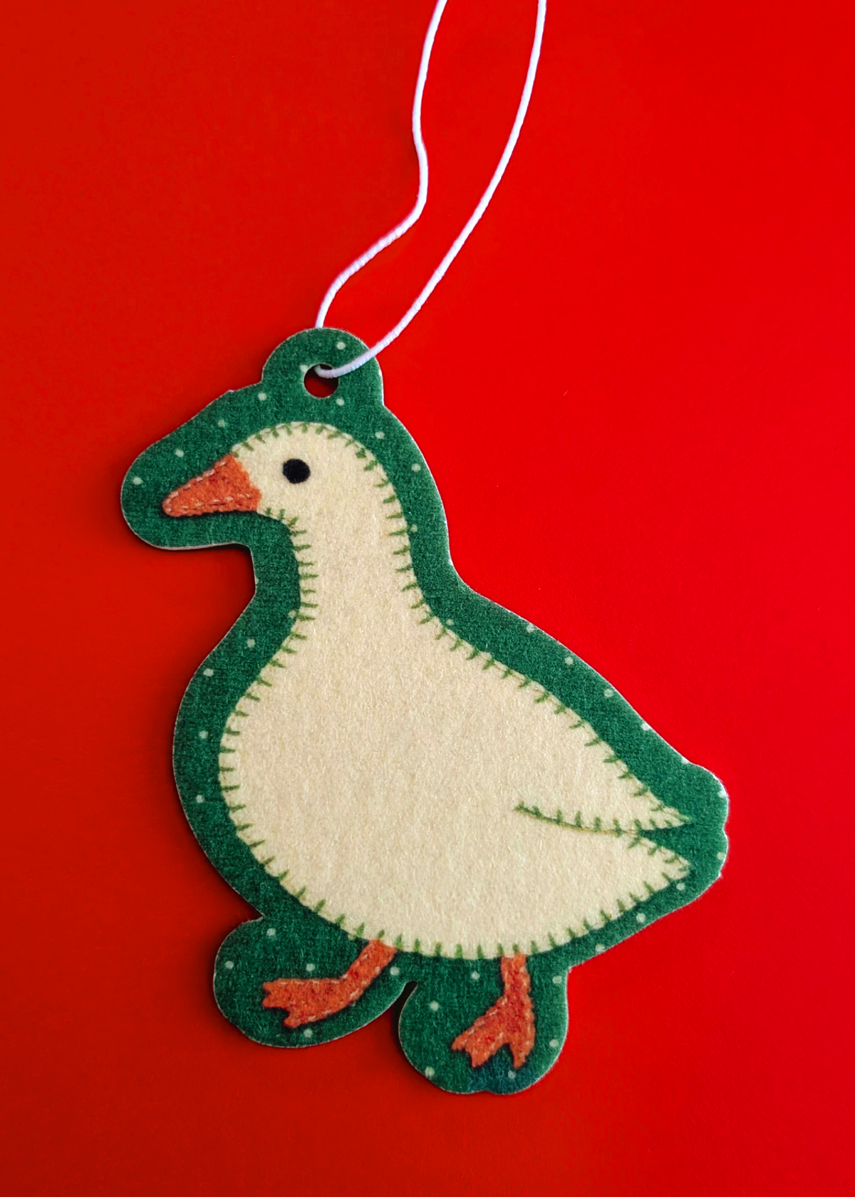 Goose shaped hanging air freshener on a red background