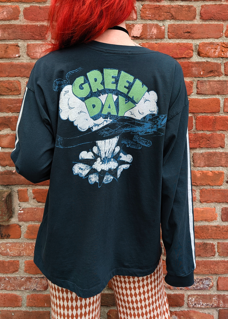 Daydreamer LA Green Day Dookie Long Sleeve Tee with puff print details and sporty athletic white stripes down the arms. Ribbed cuffs. Black colorway.  - Back graphics feature Green Day logo with airplane and "Dookie" bombs