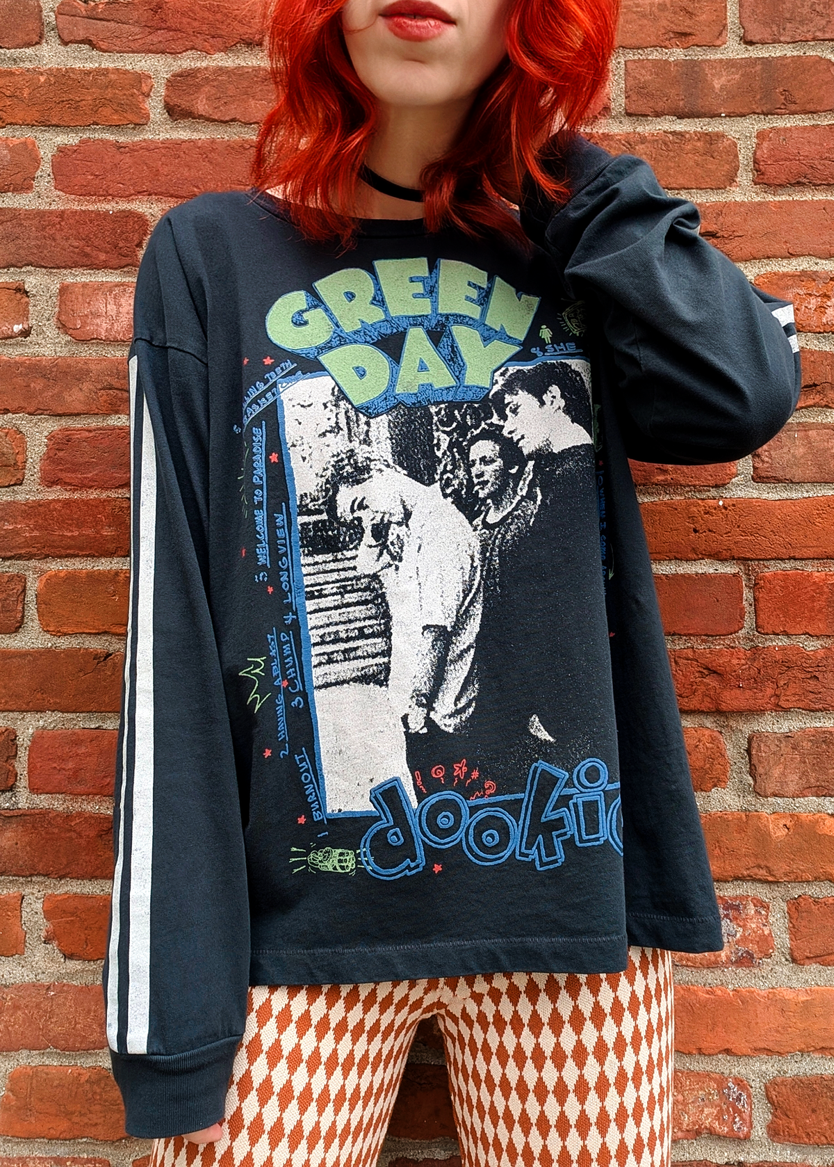 Daydreamer LA Green Day Dookie Long Sleeve Tee with puff print details and sporty athletic white stripes down the arms. Ribbed cuffs. Black colorway. 