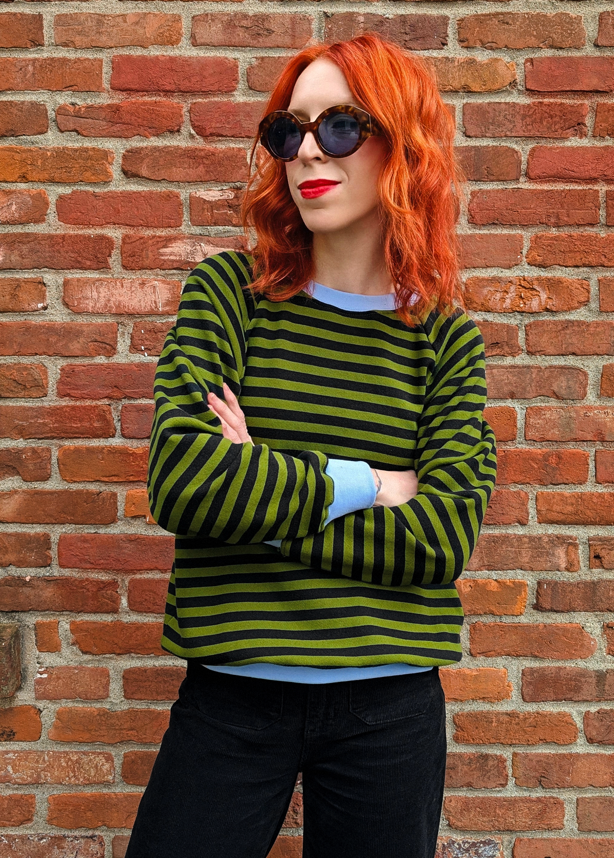 Olive green and black stripe raglan crew neck sweatshirt with ribbed sky blue cuffs, collar, and hem. Slouchy, relaxed fit. Made of 100% french Terry cotton