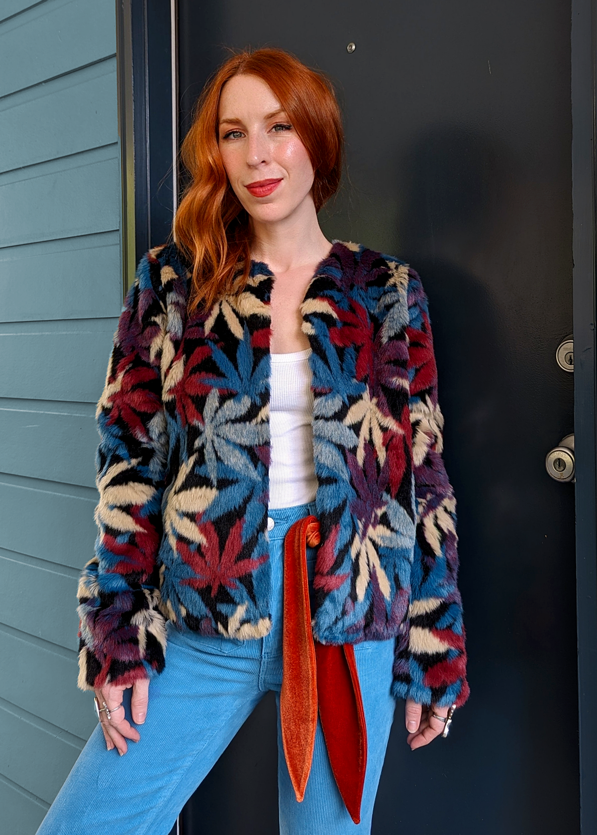 70s inspired faux fur jacket coat with colorful pot leaf design allover in teal, blue, maroon, purple, beige, and black. Open front with a collarless style. 