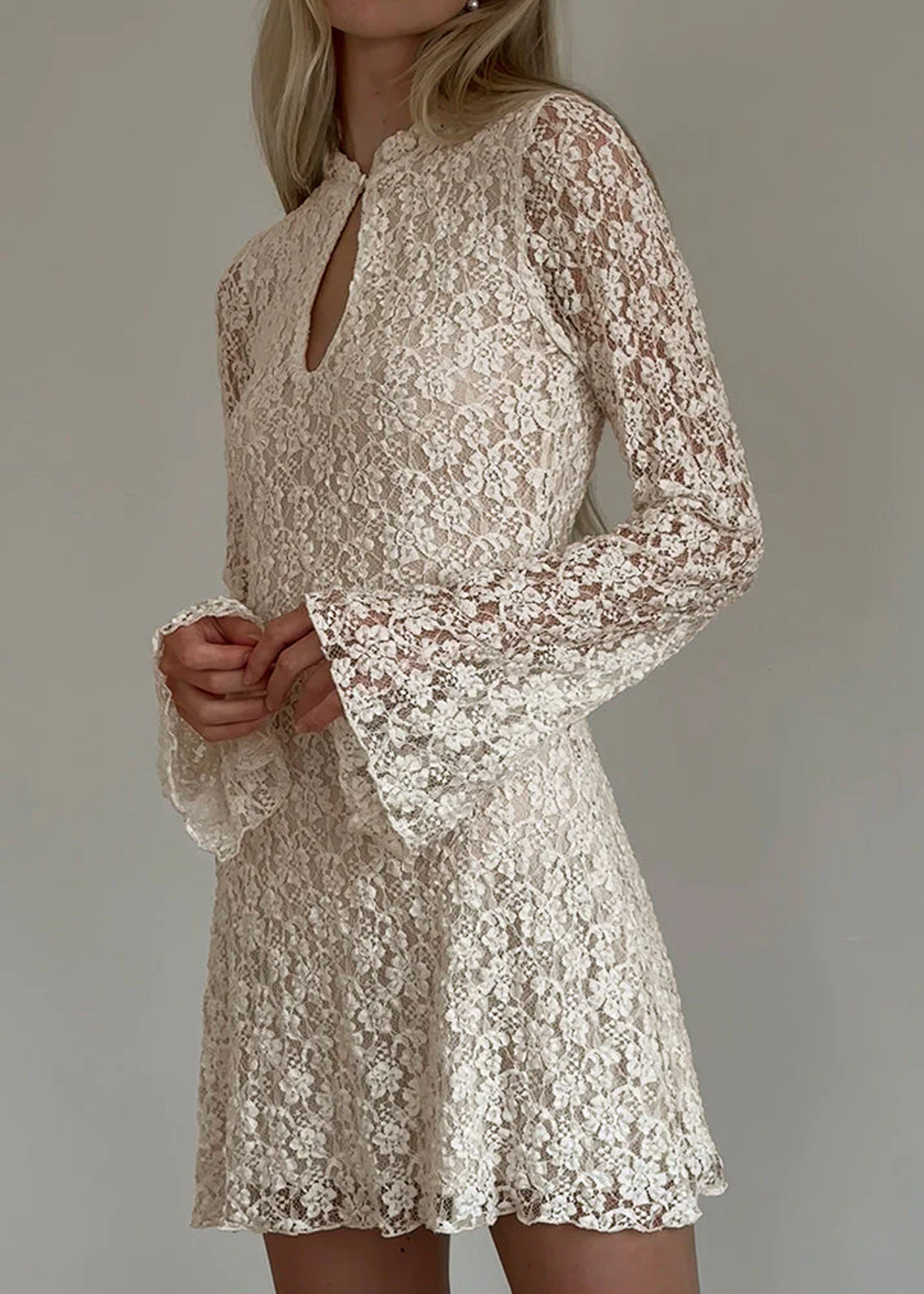 60s-inspired wedding dress! Ivory Floral Lace Bell Sleeve Mini Dress with high neckline and keyhole cutout at front. Lined through the body, sheer through sleeves. By Motel Rocks. 