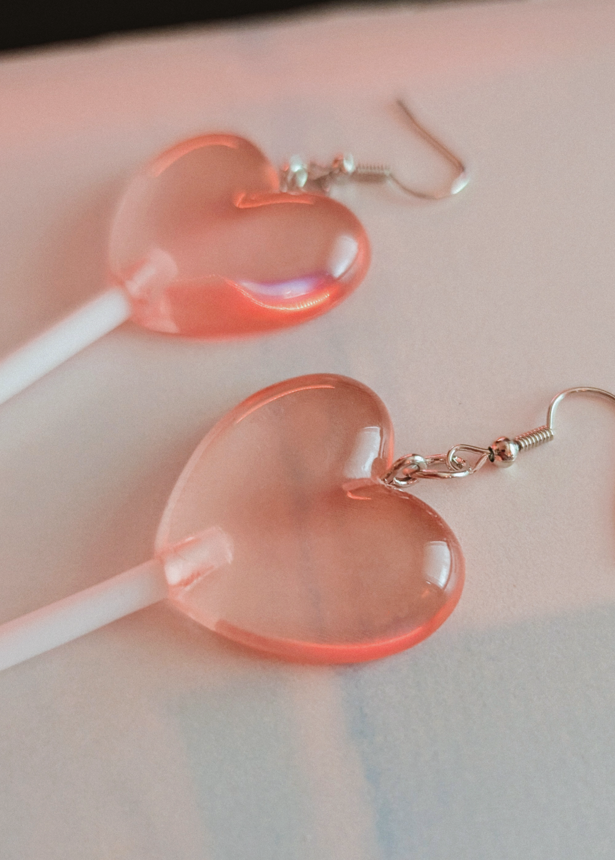 Heart-shaped lollipop earrings on a light background