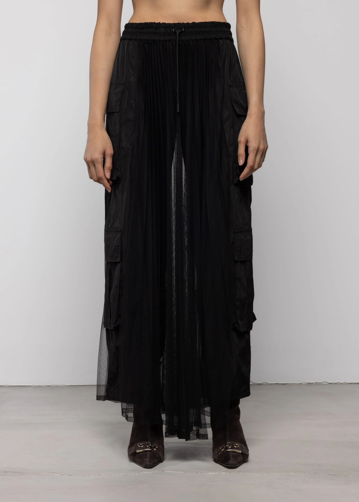 Black layered skirt worn by a person on a white background