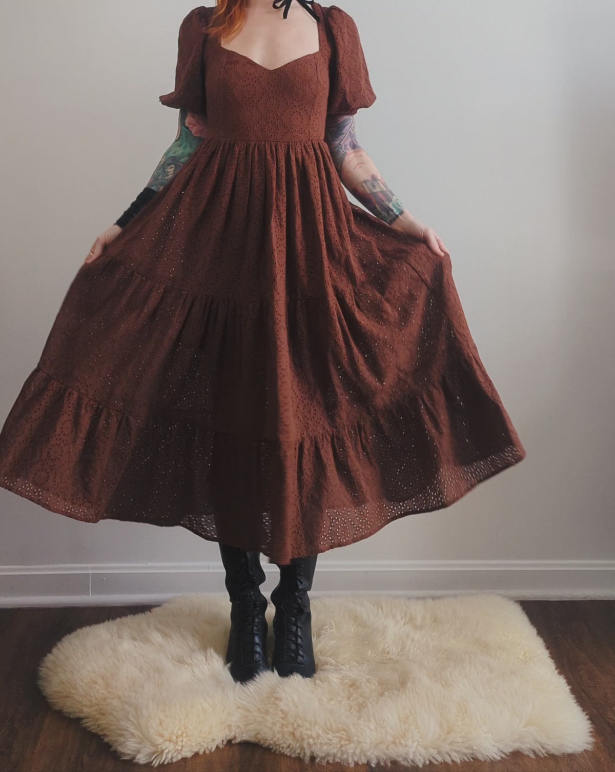 70s inspired prairie dress made of 100% eyelet cotton in a walnut brown colorway. Features puff sleeves, sweetheart neckline, smocked back with tie closure, and ruffled tiered skirt. 