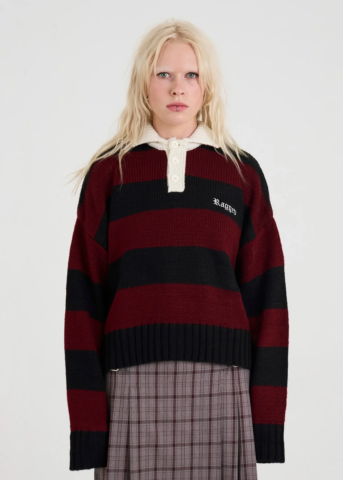 Person wearing a red and black striped sweater with a brand logo on a white background