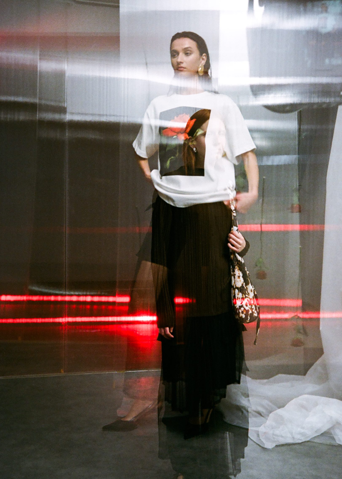 Woman wearing a white  t-shirt with  rose graphic t-shirt paired with a sheer black mesh cargo skirt 