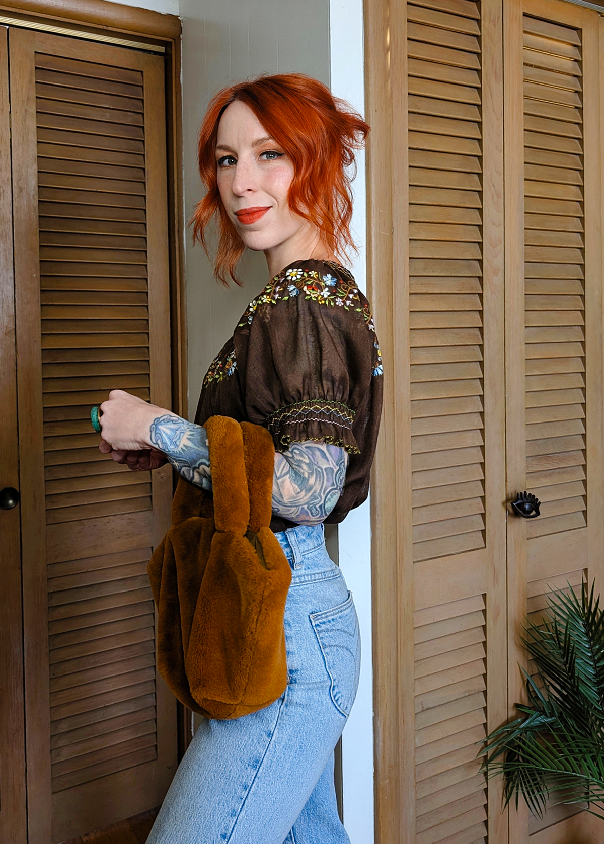 Vintage 1970s gauzy cotton prairie Penny Lane blouse featuring a round neckline, short puff sleeves, and colorful floral embroidery along neckline. Chocolate brown colorway