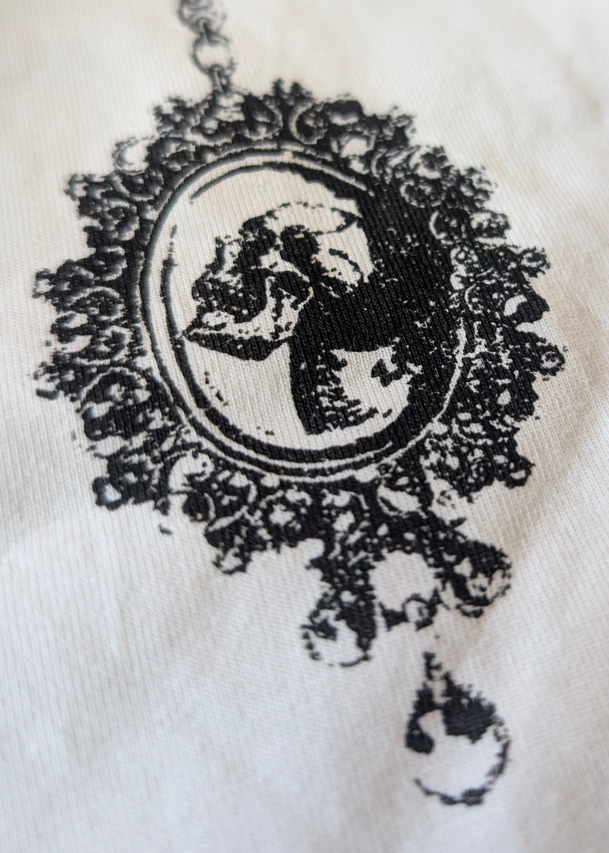 Details of the skull cameo necklace graphics on an ivory background