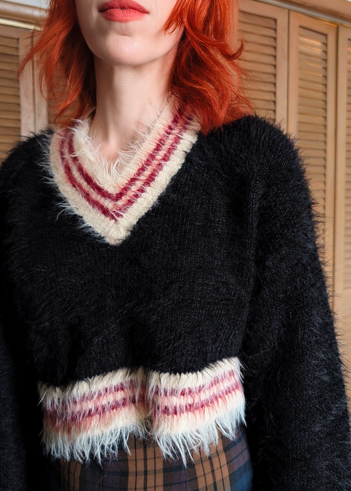 '90s inspired fluffy v-neck varsity crop length Snitch sweater by Ragged Priest. Black with cream and burgundy red stripes. 