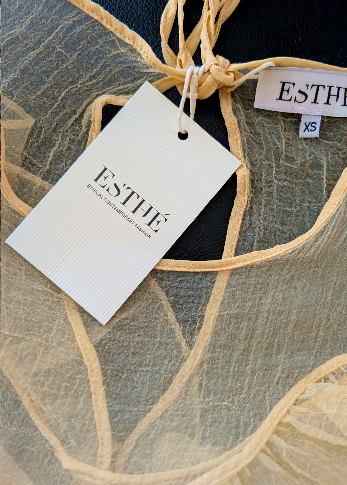 close up detail of the yellow organza top with brand's hangtag