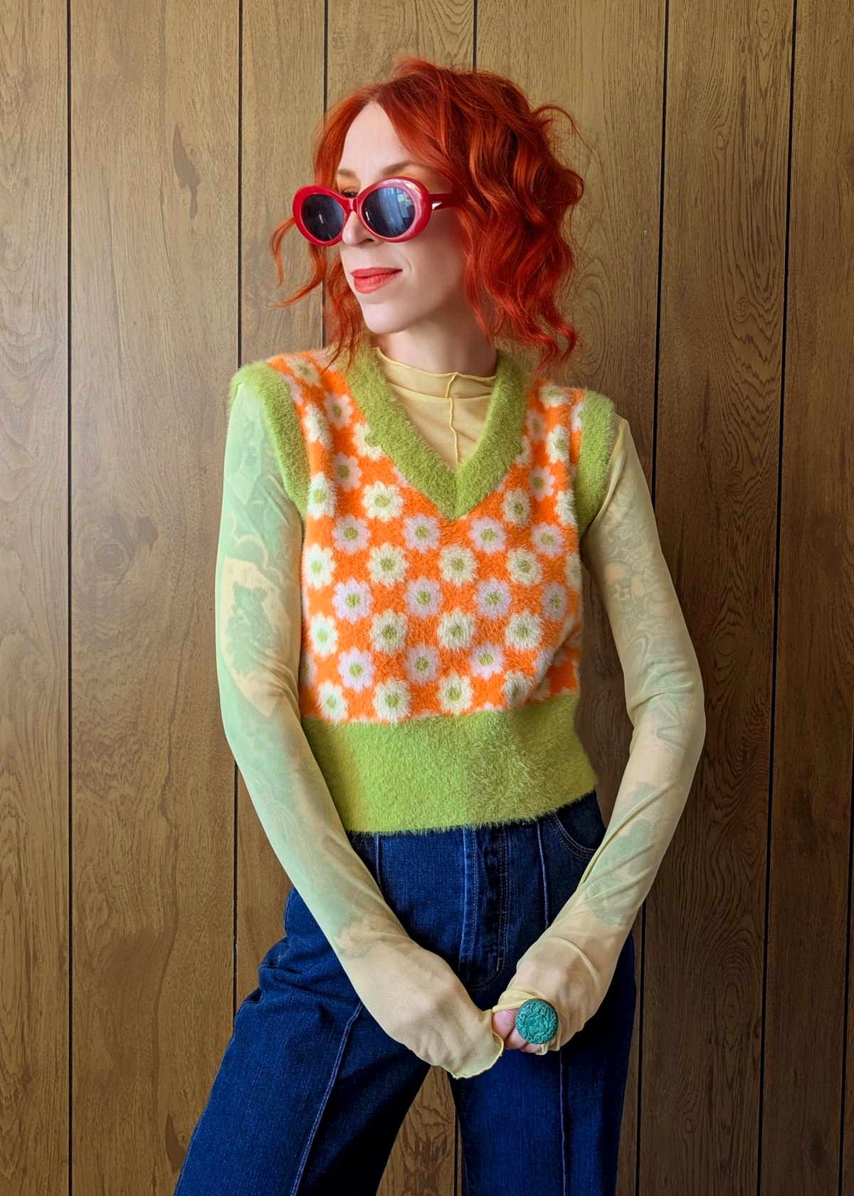 Person wearing a colorful patterned vest against a wooden background