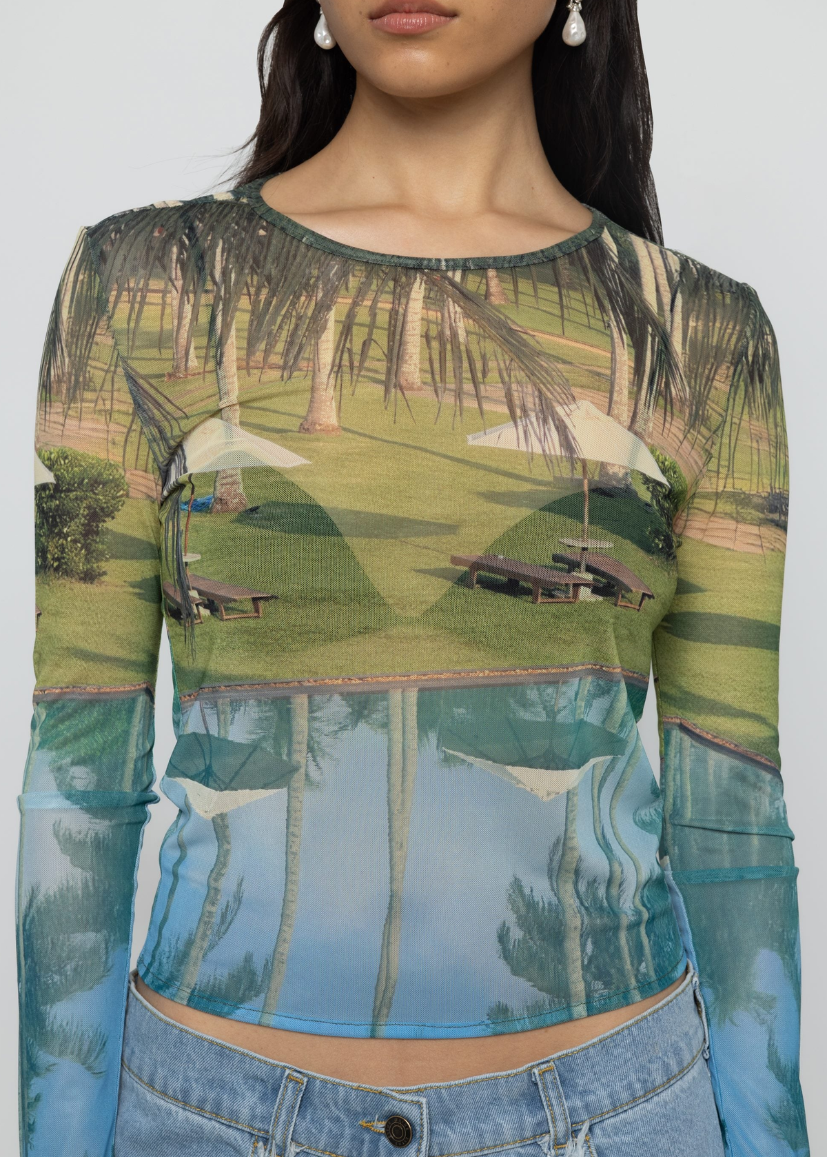 Long-sleeve mesh shirt with tropical scene print worn by a woman